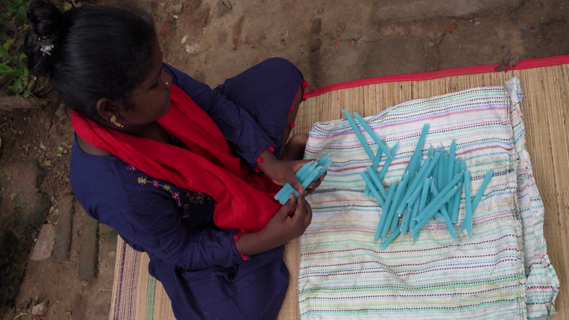 Santhana Mary þarf fyrst að rúlla kertunum saman svo þau festist ekki hvert við annað.